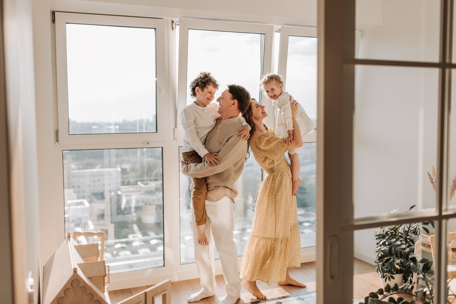 Happy family enjoying natural light through their new living room window
