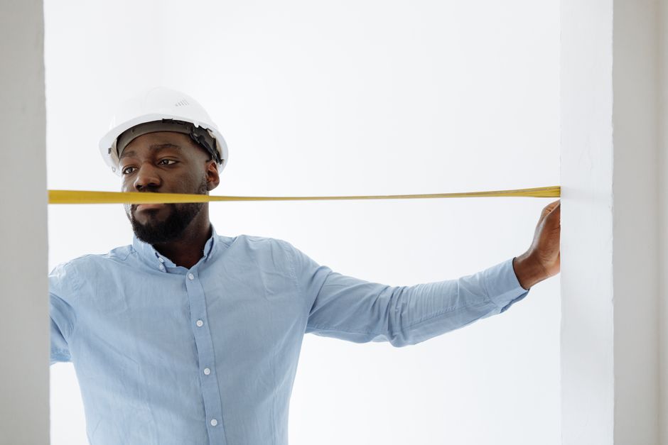 Professional worker measuring a window frame for exact fit